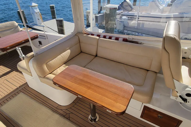Slide: The Image of 2017 MJM 40z Downeast yacht interior with beige seating and wooden table. - 14