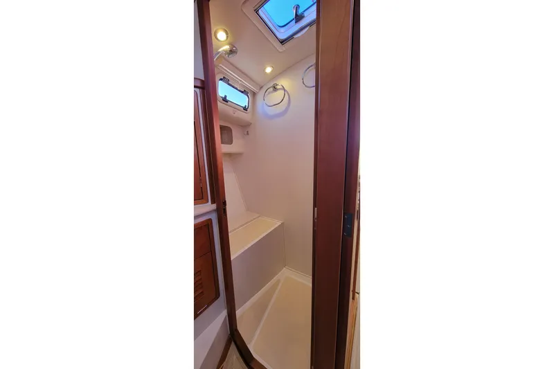 Slide: The Image of 2017 MJM 40z Downeast yacht interior shower with wooden accents and overhead lighting. - 26