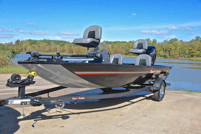 Slide: The Image of 2024 Bass Tracker Classic boat on trailer by a lake, under clear blue sky. - 10