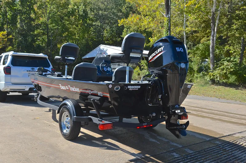 Slide: The Image of 2024 Bass Tracker Classic boat with Mercury 50 engine on trailer, parked outdoors. - 12