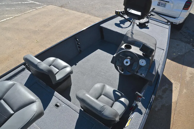 Slide: The Image of 2024 Bass Tracker Classic boat interior with steering console and seating. - 21