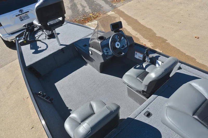Slide: The Image of 2024 Bass Tracker Classic boat interior with gray seating and steering console. - 22