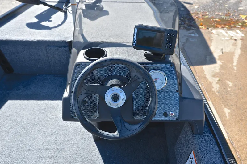 Slide: The Image of 2024 Bass Tracker Classic boat dashboard with steering wheel and navigation display. - 24