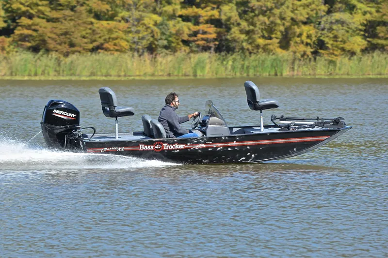 Slide: The Image of 2024 Bass Tracker Classic boat speeding on a lake with a Mercury engine. - 3