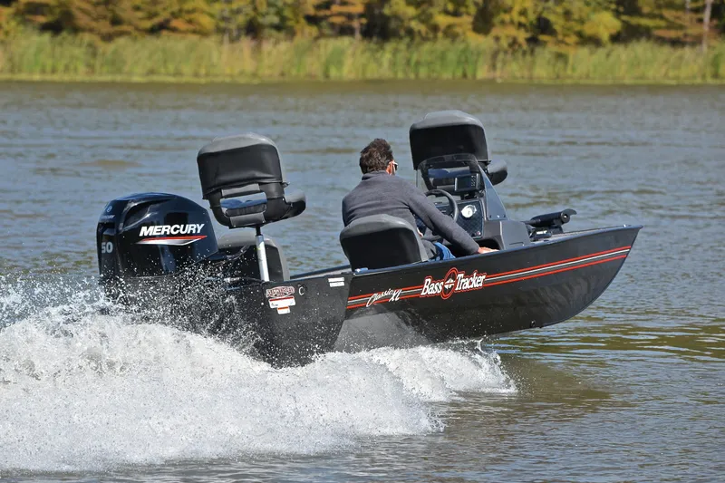 Slide: The Image of 2024 Bass Tracker Classic boat cruising on a lake with Mercury engine. - 5