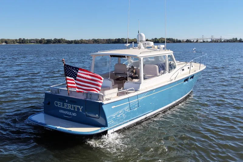 Slide: The Image of 2011 MJM 40z Downeast boat cruising on water with American flag, Annapolis, MD. - 2
