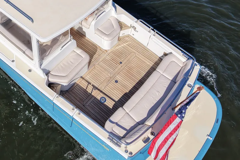 Slide: The Image of 2011 MJM 40z Downeast boat with teak deck and American flag on water. - 8