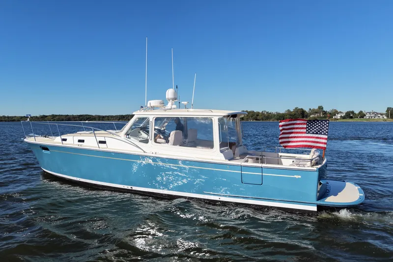 Slide: The Image of 2011 MJM 40z Downeast boat cruising on a sunny day with an American flag. - 3