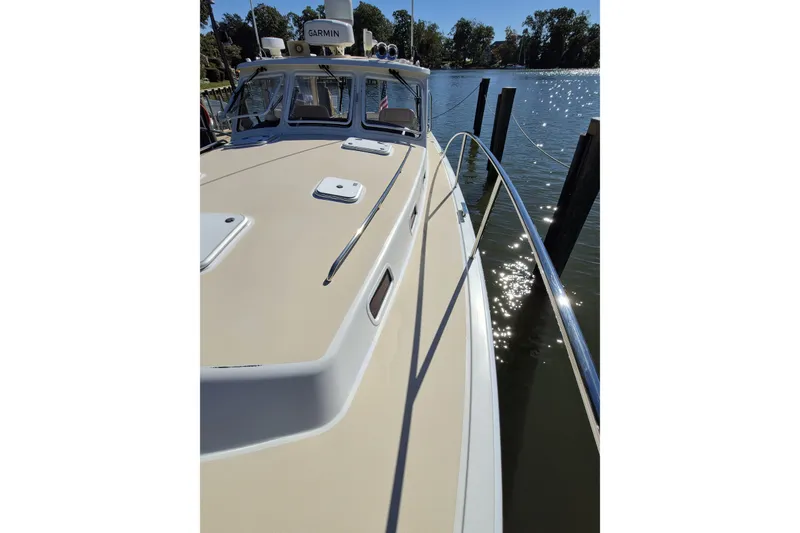Slide: The Image of 2011 MJM 40z Downeast boat docked by the water, featuring a sleek deck design. - 12