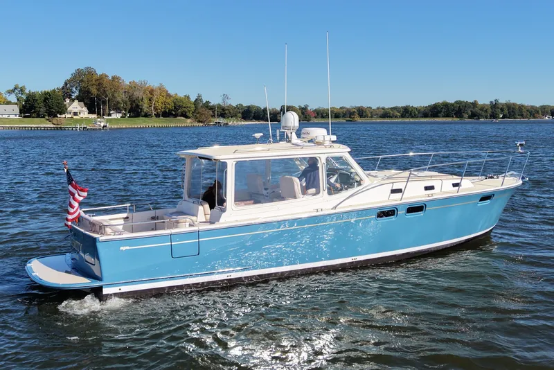 The Image of 2011 MJM 40z Downeast boat cruising on a sunny day with scenic shoreline. - 0