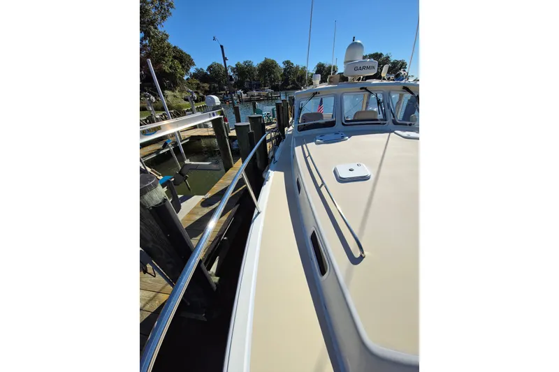Slide: The Image of 2011 MJM 40z Downeast boat docked at a marina under clear blue skies. - 11