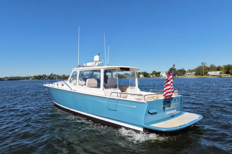 Slide: The Image of 2011 MJM 40z Downeast boat cruising on a sunny day with American flag. - 5