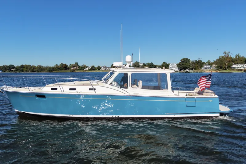 Slide: The Image of 2011 MJM 40z Downeast boat cruising on a sunny day with American flag. - 4