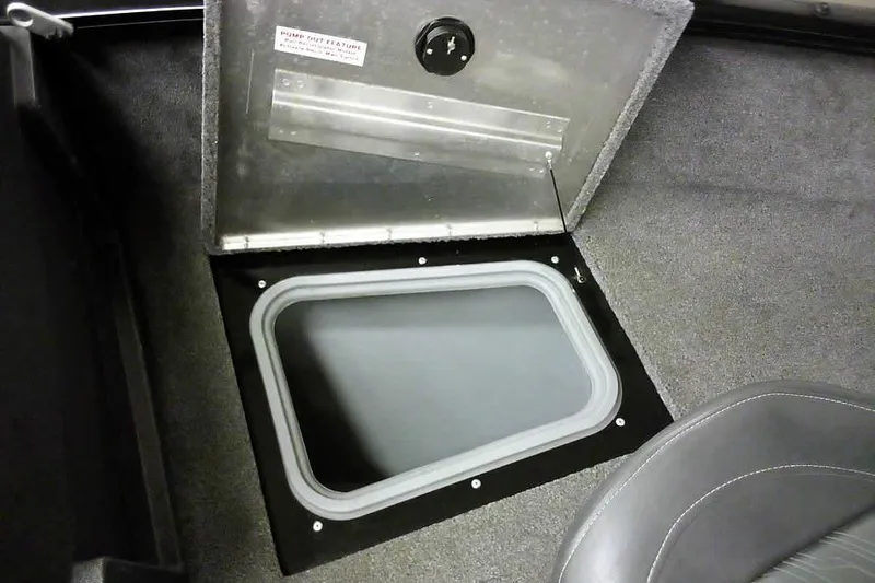 Slide: The Image of 2022 Tracker Pro Guide V-16 WT boat storage compartment with open hatch and carpeted interior. - 11