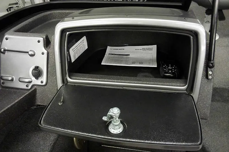 Slide: The Image of 2022 Tracker Pro Guide V-16 WT boat storage compartment with documents and device. - 18