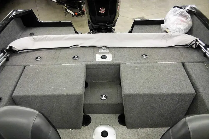 Slide: The Image of 2022 Tracker Pro Guide V-16 WT boat interior with gray carpeted storage compartments. - 27