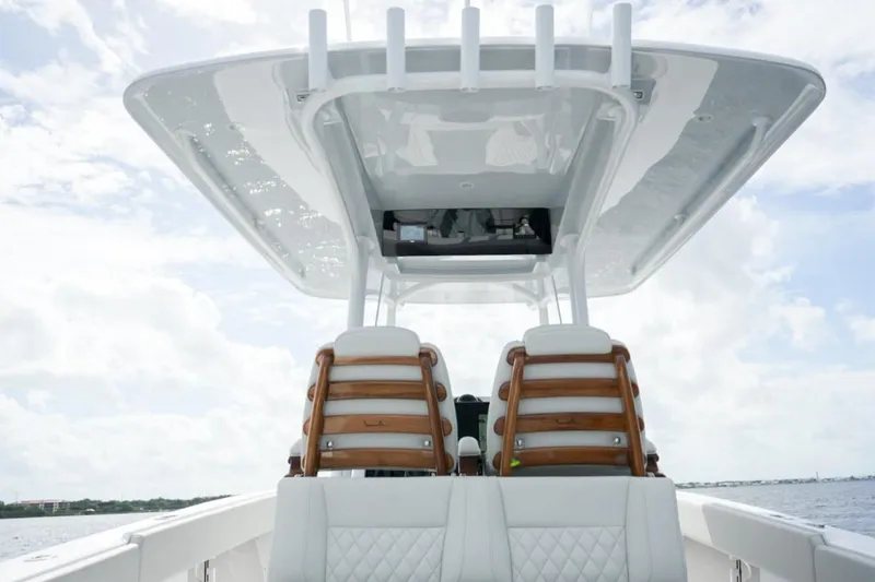 Slide: The Image of Luxury seating on a 2026 Jupiter 30 boat, featuring elegant white upholstery and wooden armrests. - 28