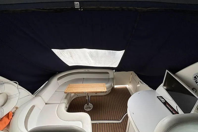 Slide: The Image of 2005 Sea Ray 340 Sundancer interior with seating, table, and TV under a canopy. - 12