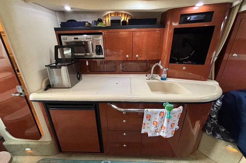 Slide: The Image of 2005 Sea Ray 340 Sundancer galley with sink, microwave, and storage cabinets. - 24