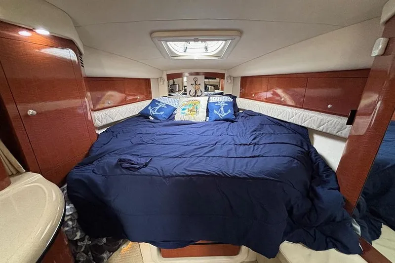 Slide: The Image of Luxurious cabin interior of 2005 Sea Ray 340 Sundancer with cozy bedding and wooden accents. - 25