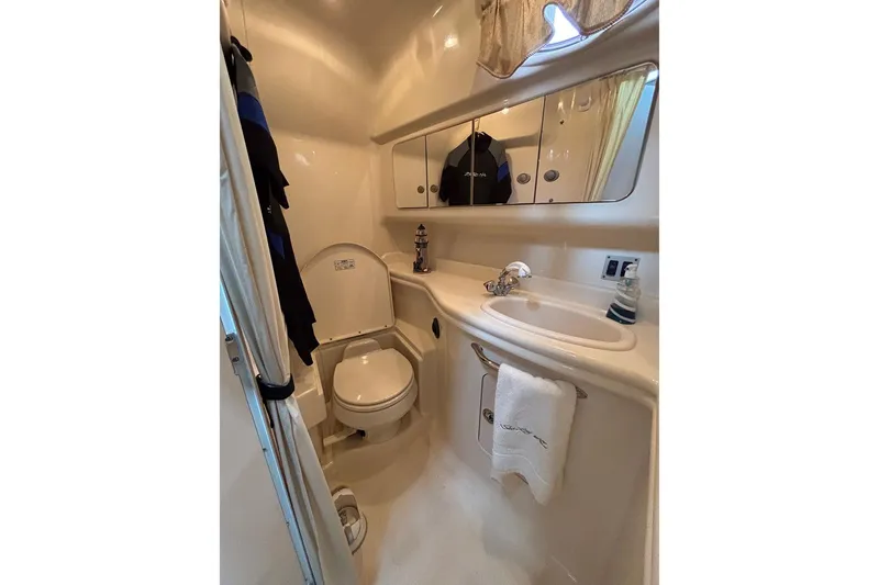 Slide: The Image of 2005 Sea Ray 340 Sundancer bathroom with toilet, sink, mirror, and towel. - 26