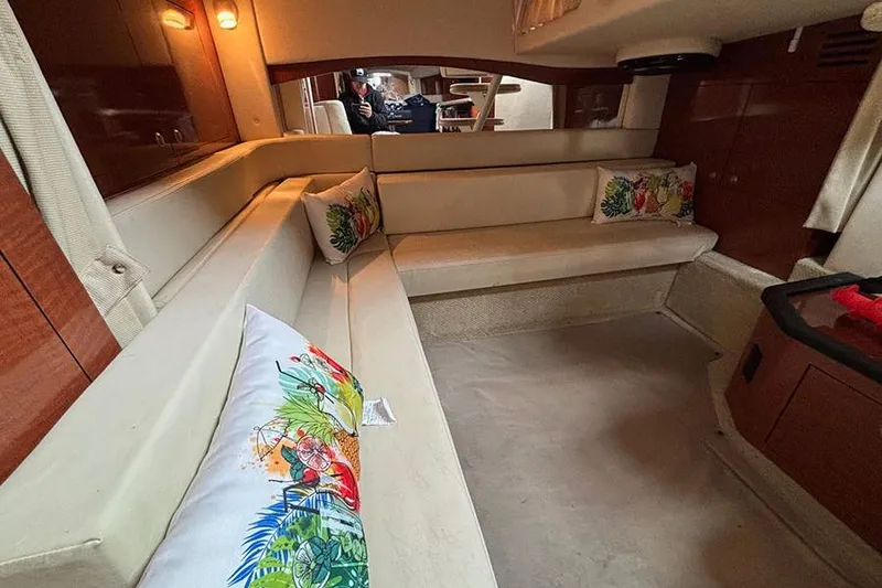 Slide: The Image of Interior of 2005 Sea Ray 340 Sundancer with beige seating and colorful pillows. - 27