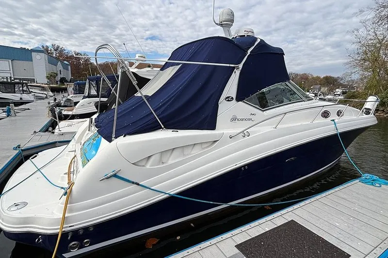 Slide: The Image of 2005 Sea Ray 340 Sundancer docked, featuring a blue and white design with covered cockpit. - 4