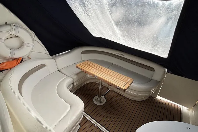 Slide: The Image of 2005 Sea Ray 340 Sundancer interior with cushioned seating and wooden table. - 5