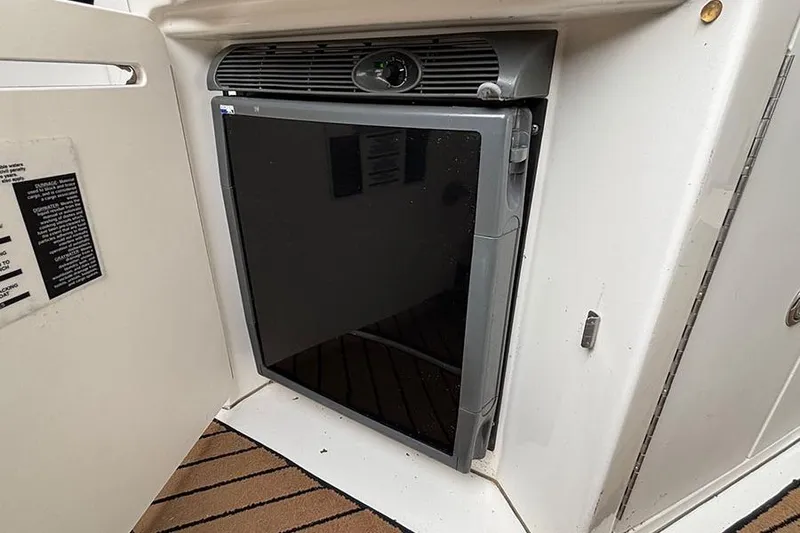 Slide: The Image of Compact refrigerator in 2005 Sea Ray 340 Sundancer boat, open cabinet, white interior. - 7
