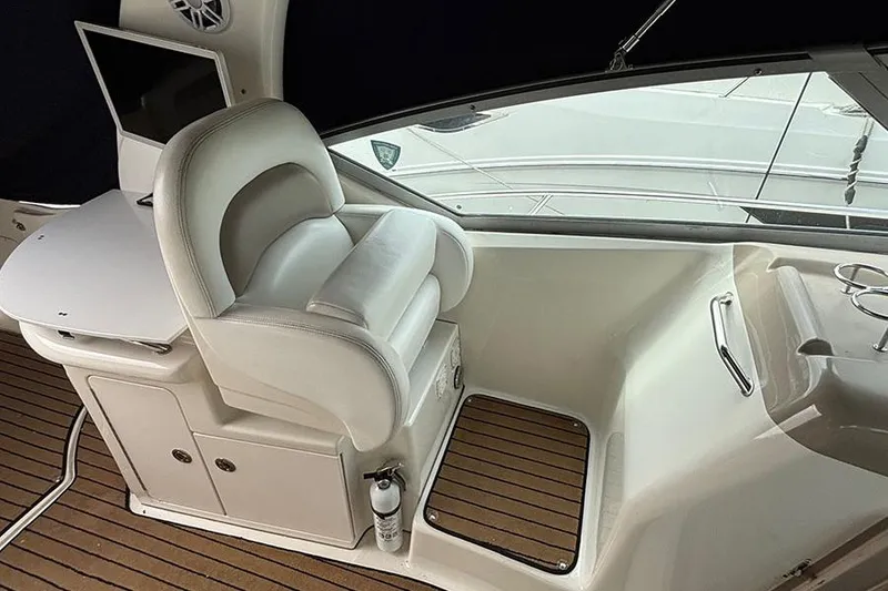 Slide: The Image of 2005 Sea Ray 340 Sundancer helm with white captain's chair and wooden deck. - 9