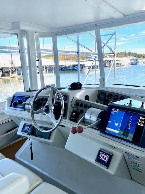 Slide: The Image of 1999 Carver 456 Aft Cabin Motor Yacht helm with modern navigation equipment and waterfront view. - 10