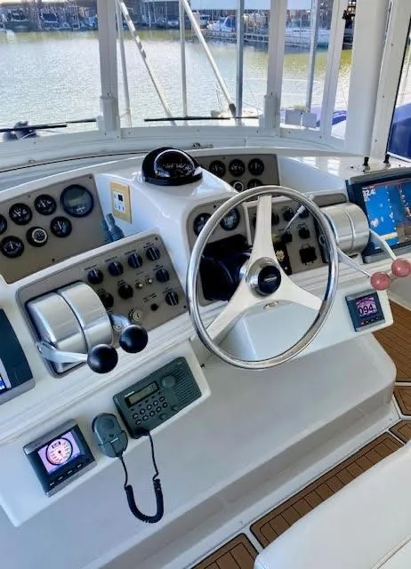 Slide: The Image of 1999 Carver 456 Aft Cabin Motor Yacht helm with steering wheel and control panels. - 11