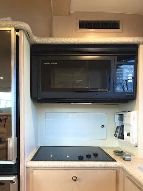 Slide: The Image of 1999 Carver 456 Aft Cabin Motor Yacht kitchen with microwave and stovetop. - 22