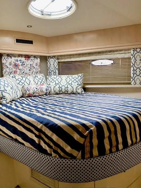 Slide: The Image of 1999 Carver 456 Aft Cabin Motor Yacht bedroom with striped bedding and decorative pillows. - 28