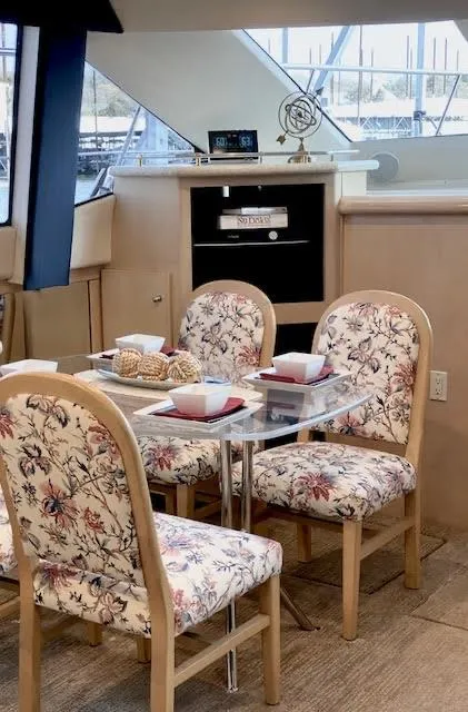 Slide: The Image of Dining area in 1999 Carver 456 Aft Cabin Motor Yacht with floral chairs and elegant table setting. - 40