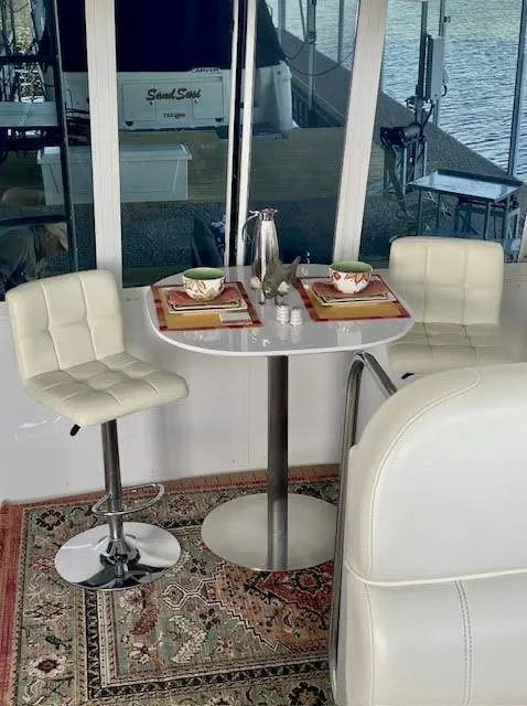 Slide: The Image of 1999 Carver 456 Aft Cabin Motor Yacht interior with dining setup and white seating. - 19