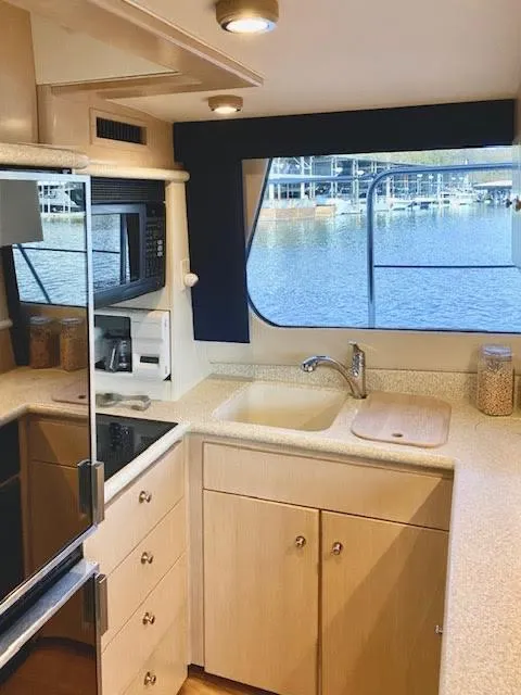 Slide: The Image of 1999 Carver 456 Aft Cabin Motor Yacht kitchen with modern appliances and waterfront view. - 21