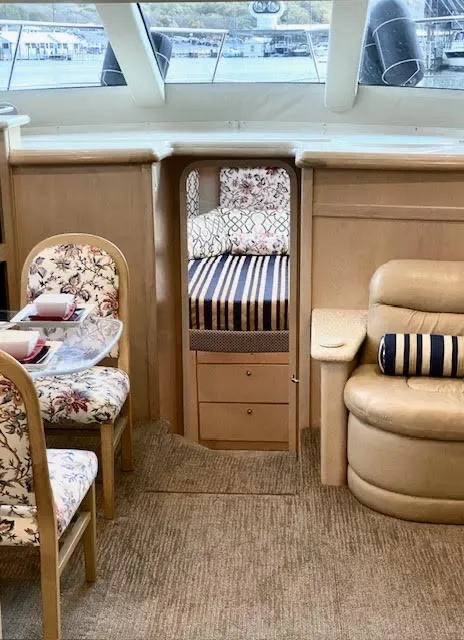 Slide: The Image of 1999 Carver 456 Aft Cabin Motor Yacht interior with floral seating and cozy cabin. - 24
