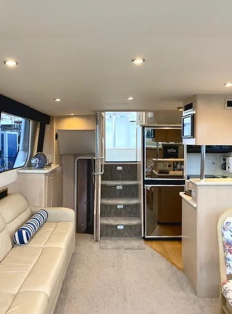 Slide: The Image of 1999 Carver 456 Aft Cabin Motor Yacht interior with beige seating and modern kitchen. - 31