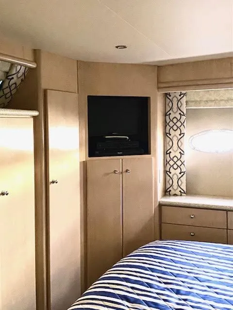 Slide: The Image of Interior of 1999 Carver 456 Aft Cabin Motor Yacht with TV and striped bedding. - 35