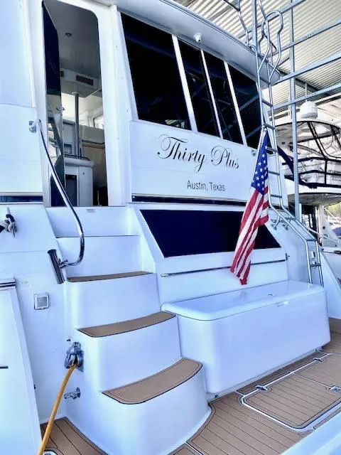 Slide: The Image of 1999 Carver 456 Aft Cabin Motor Yacht docked, featuring steps and American flag, Austin, Texas. - 7
