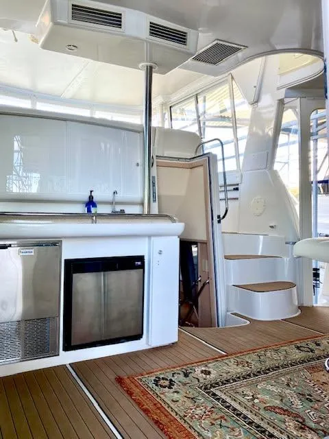 Slide: The Image of 1999 Carver 456 Aft Cabin Motor Yacht interior with kitchenette and spiral staircase. - 8