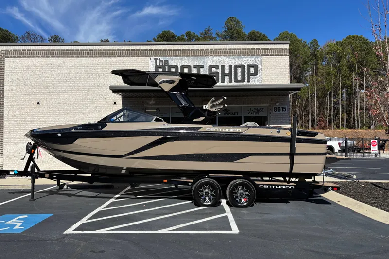 The Image of 2026 Centurion Ri265 boat on trailer outside The Boat Shop, surrounded by trees. - 0