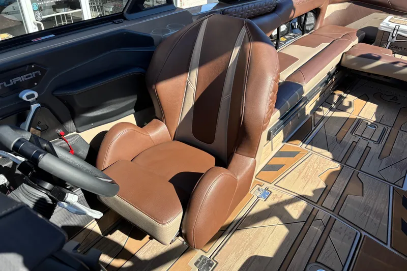 Slide: The Image of 2026 Centurion Ri265 boat interior with brown leather seating and modern dashboard. - 11