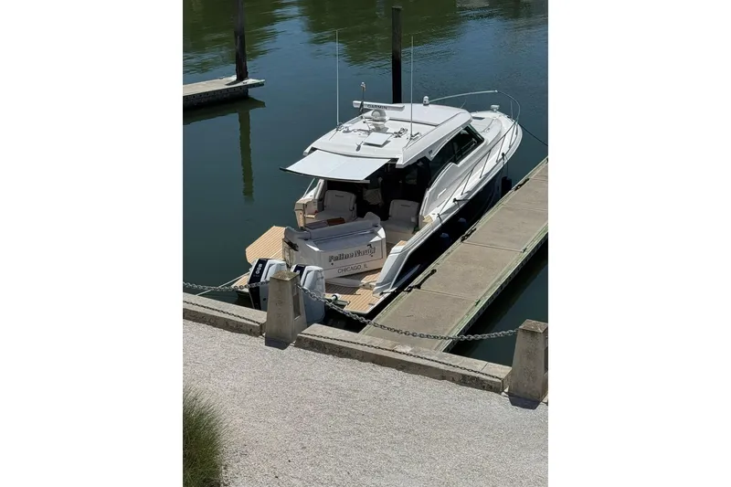 Slide: The Image of 2025 Tiara Yachts 43 LE docked in a marina, rear view. - 17
