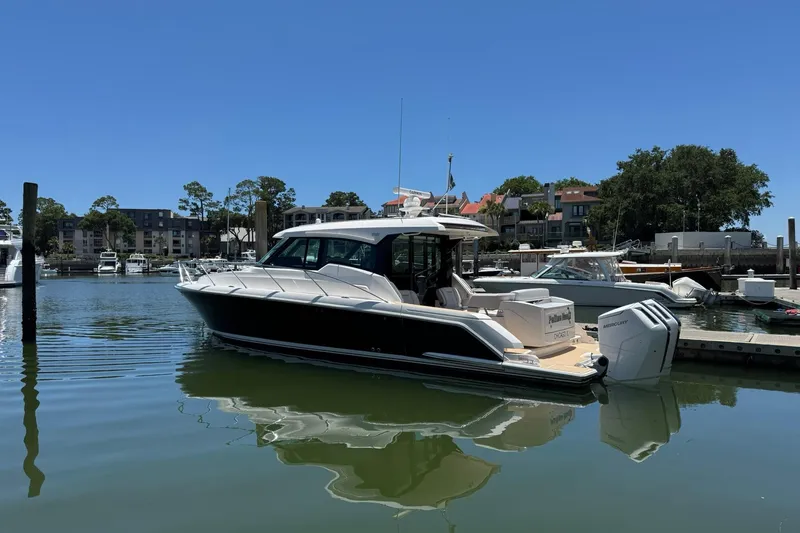 Slide: The Image of 2025 Tiara Yachts 43 LE docked in a serene marina setting. - 18