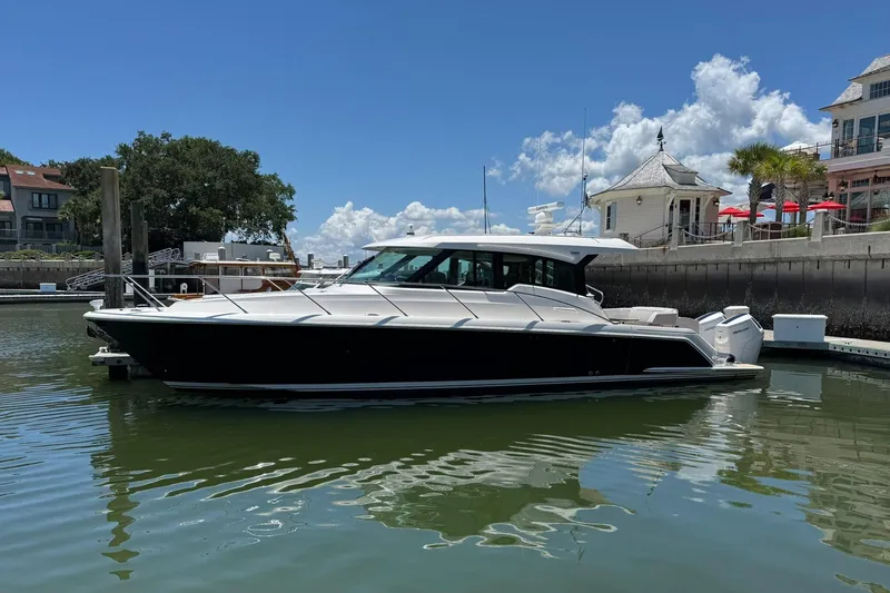 Slide: The Image of 2025 Tiara Yachts 43 LE docked in a scenic marina setting. - 19