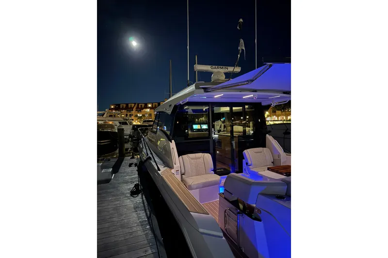 Slide: The Image of 2025 Tiara Yachts 43 LE docked at night, illuminated under moonlight. - 20