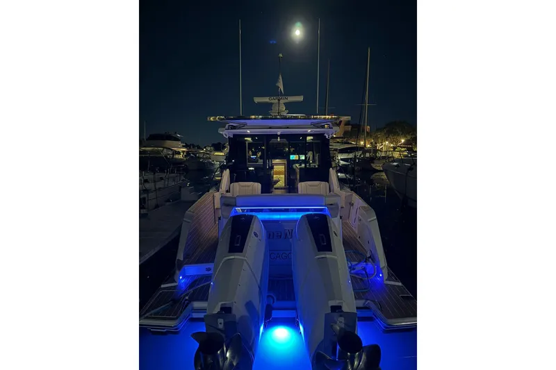 Slide: The Image of 2025 Tiara Yachts 43 LE illuminated at night in a marina setting. - 21