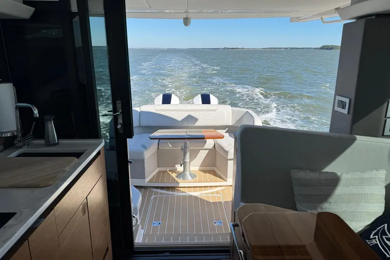 Slide: The Image of Interior view of 2025 Tiara Yachts 43 LE, featuring elegant seating and ocean backdrop. - 23